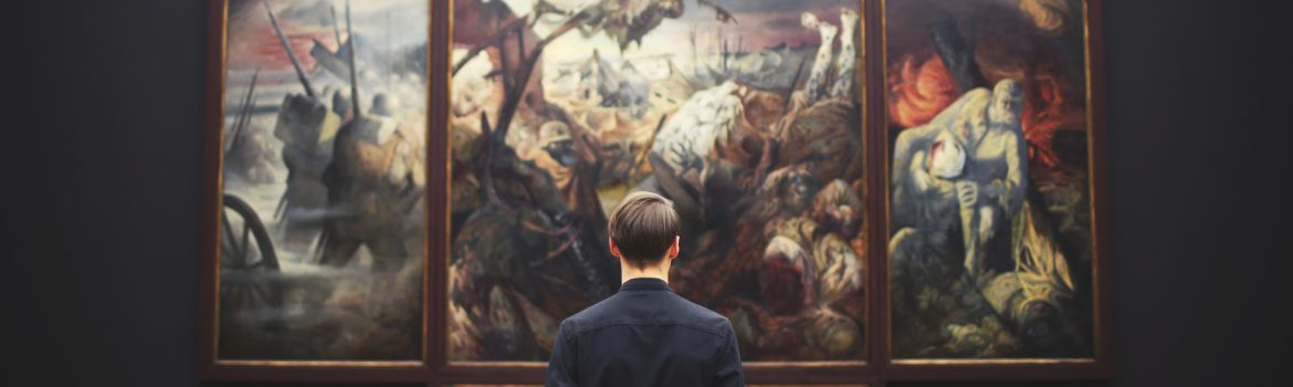 A student in black, in a museum pore over a great painting.