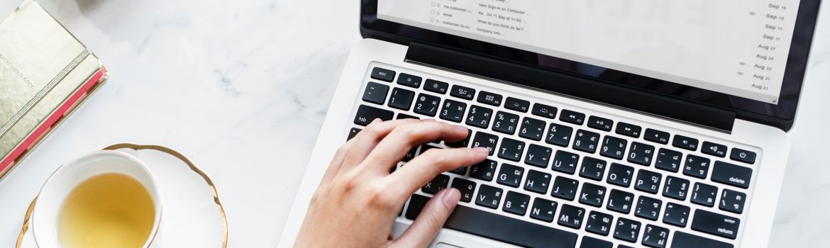 A girl searching some files on Macbook with cup of tea on the table.