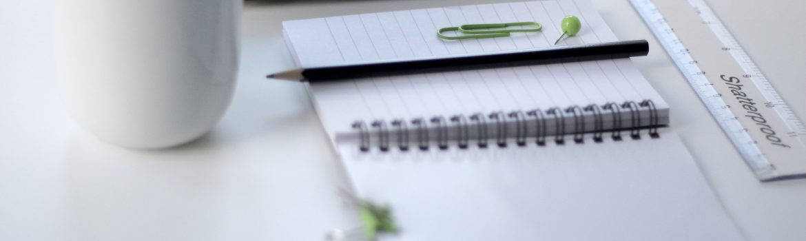 Laptop with notebook and pencils with a cup. Organizing your workplace - you organize your thoughts.