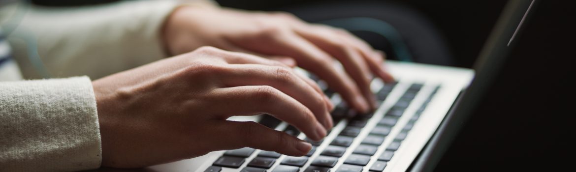 The laptop and a girl typing the text on the keyboard or searching something among the web.