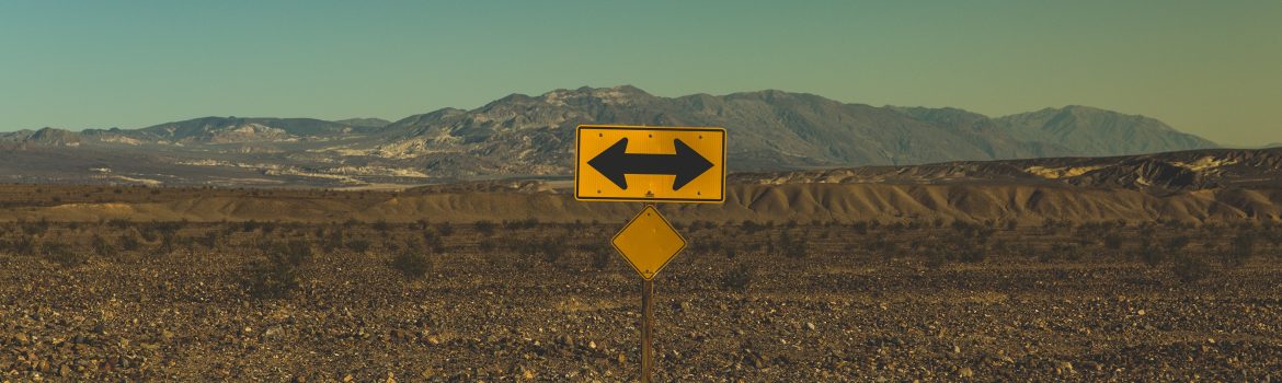 Street sign on the road in the region of desert and mountains.