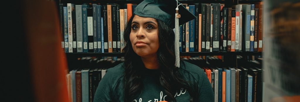 Banner with a student holding books in a library for an article