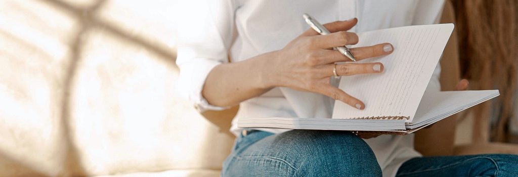 A girl writing her notes in her notebook.